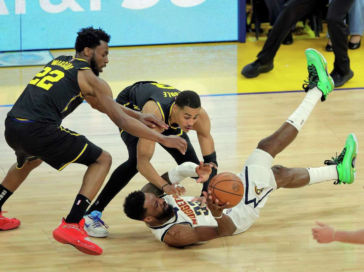 Andrew Wiggins (22) and Jordan Poole (3) try to get a loose ball away from Jeff Green (32) In the second half as the Golden State Warriors played the Denver Nuggets in Game 5 of the first round of the NBA Playoffs at Chase Center in San Francisco, Calif., on Wednesday, April 27, 2022.