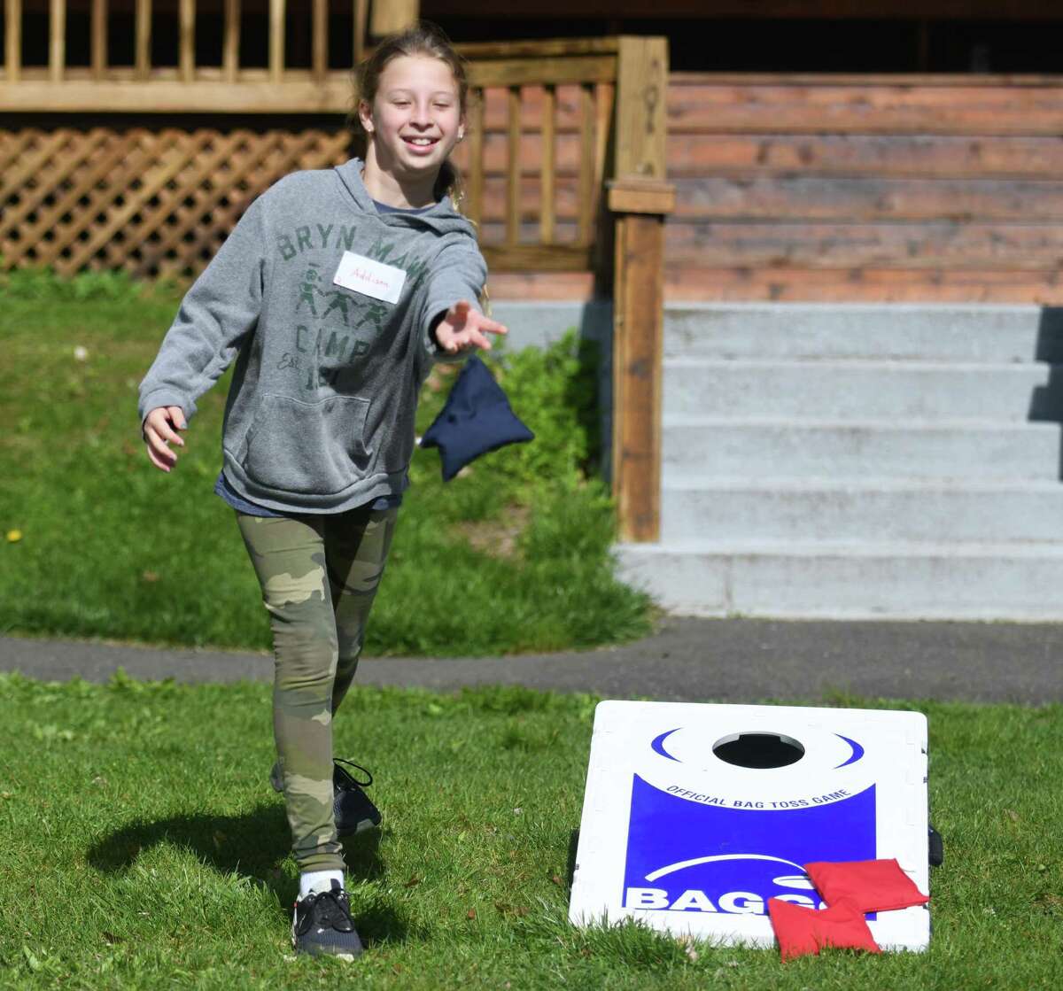 Fifth grader Addison Schamberg throws a beanbag at the Greenwich Public Schools Orientation Adventure Days at Camp Seton in Greenwich, Conn. on Wednesday, April 27, 2022. The two-decade tradition is designed to give fifth-grade students the opportunity to meet and interact with students who will be in their sixth-grade class in college next year.  The one-day camp included fun team-building activities like orienteering, rock climbing, rope balancing, bean bag tossing, ladder ball, and more.