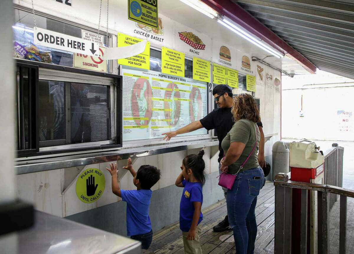 Lisbeth Cobio, center, her sons Regulo Jr. and J.J., and her grandson D.J. decide what to order at Poppa Burger on Tuesday, April 12, 2022, in Houston.