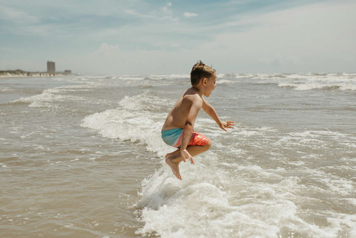 Boy jumping in the ocean in Corpus Christi, Texas. 