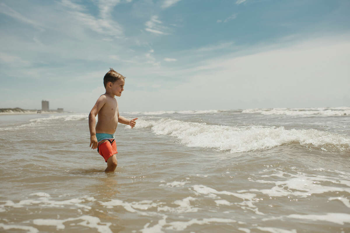 Boy playing in ocean waves in Corpus Christi, Texas. 