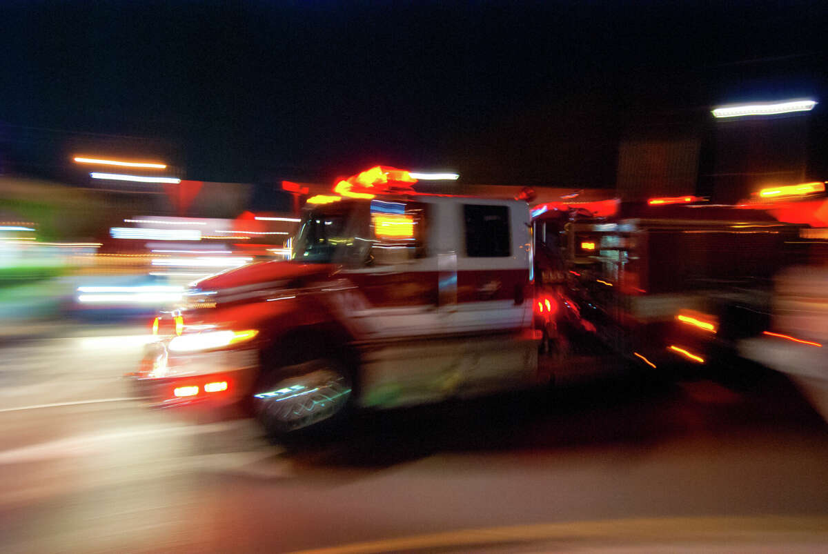 STOCK PHOTO A firetruck disrupts a quite suburban night as it rushes by in the dark, lights flashing, blurred by the rapid motion.
