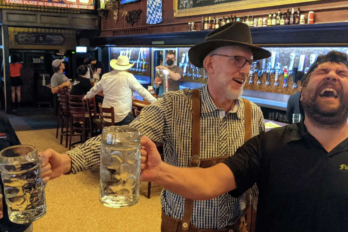 Two men enjoy a laugh at Flying Saucer Draught Emporium, a bar in downtown Houston.