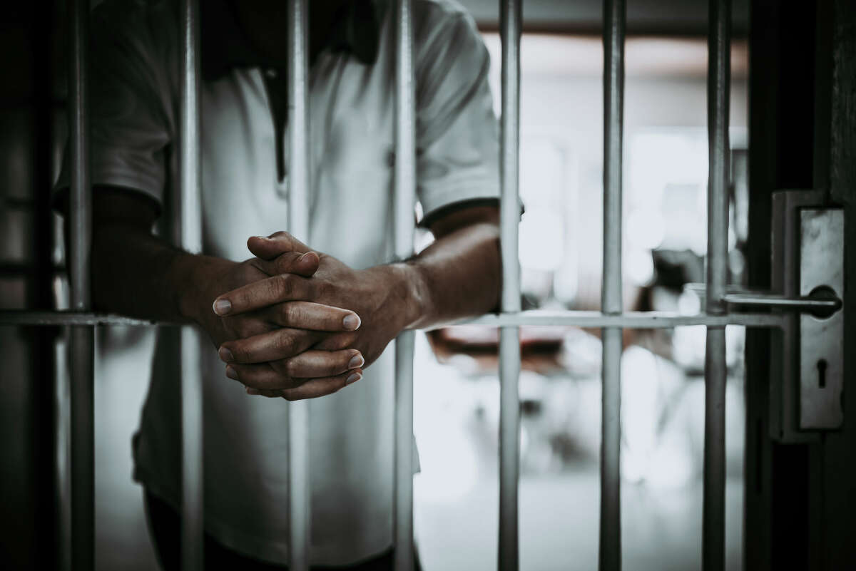 Image of a man standing in prison.