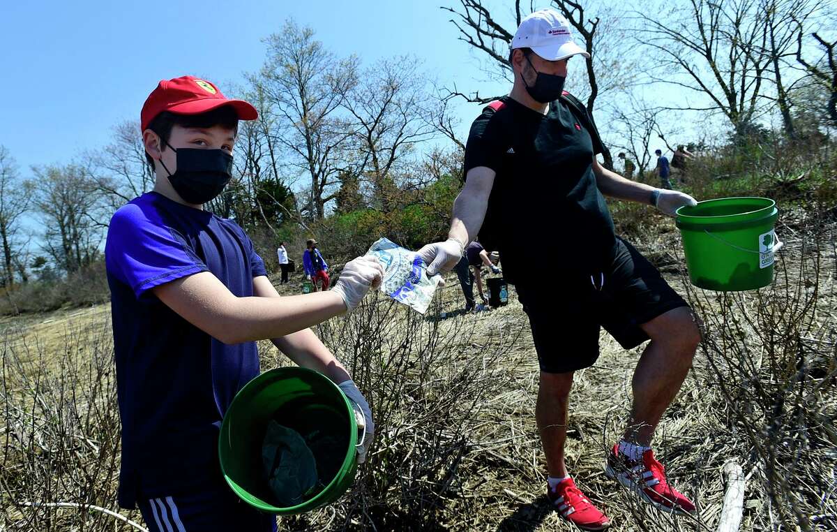 Greenwich residents, including Alex Madris and his son Diego, 10, join students from Greenwich High School’s Environmental Action Club as they lead a beach cleanup at Greenwich Point Park on Saturday, April 24, 2021, in Greenwich, Conn.