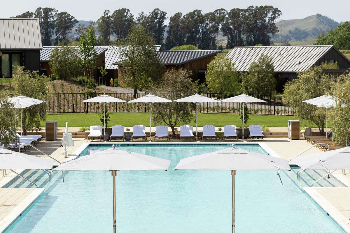 Top photo: The Lavender Pool at Stanly Ranch, now the closest Wine Country resort to San Francisco. Above: The outdoor patio of a guest room, left, and the living room of a private cabin, right, at the resort. Photos by Jessica Christian / The Chronicle