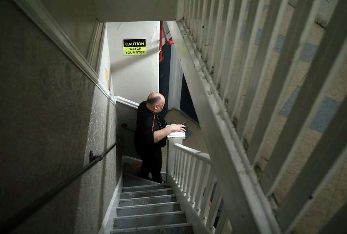 With the elevator out of service, Richard Chapman walks down a narrow staircase at Winton Hotel in San Francisco.