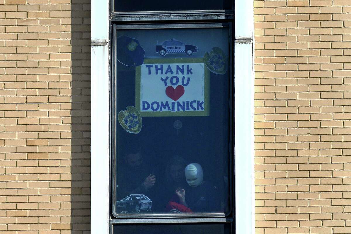 Dominick Krankall, 6, waves from his hospital room window as he watches a parade of emergency vehicles in front of Bridgeport Hospital on Thursday.