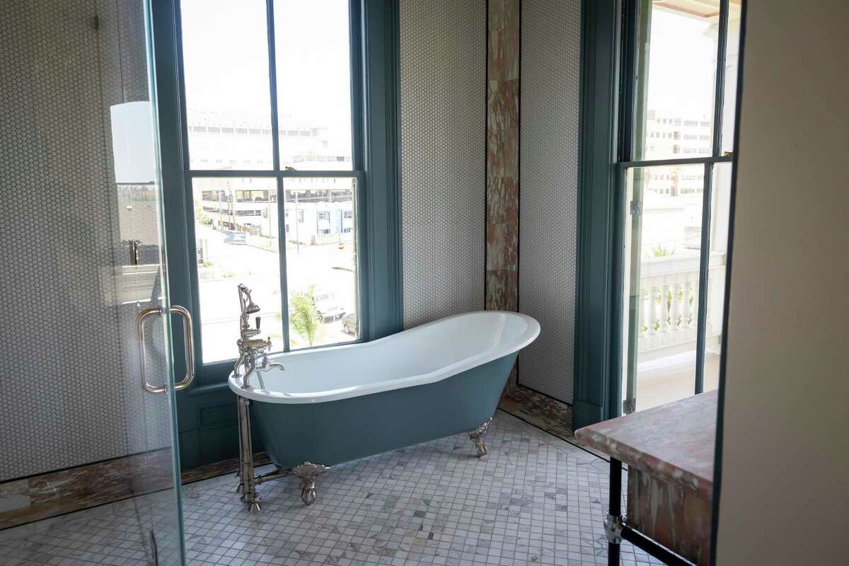 Rose tile and a clawfoot tub in one of the bathrooms on the top floor in the historic home owned and restored by design mother/daughter duo Mary Louise Stonecypher and Jordan Vaughn in Galveston on Saturday, April 22, 2022.