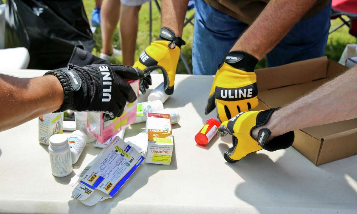U.S. Drug Enforcement Administration agents separate various pill form and liquid form prescription medication before sealing them away in boxes for proper disposal during the National Drug Take-Back Initiative day in 2014.