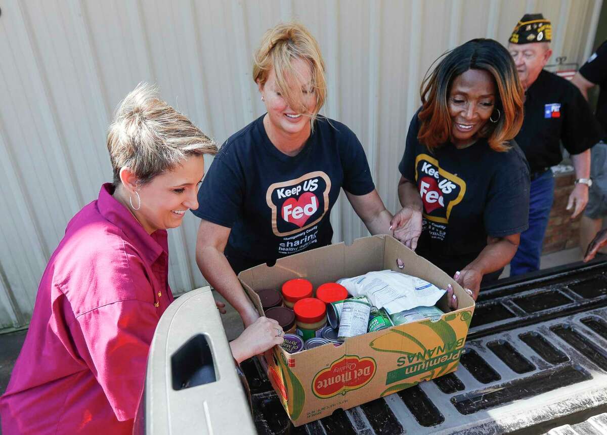 Marcey Phillips, Tiffany Baumann Nelson and Rosie Plattenburg help carry a box of food as volunteers with Keep US Fed Montgomery County, the Texas Veterans of Foreign Wars District 17 & Post 4709 gathered 554-pounds of food to donate to Camp Valor and Pilgrim Rest Baptist Church’s food pantry, Wednesday, April 27, 2022, in Conroe.