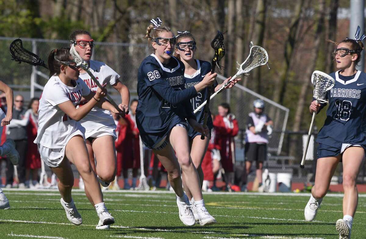 Wilton’s Ashleigh Masterson (26) controls the ball while Greenwich’s Flynn Tauber (13) defends during a girls lacrosse game in Greenwich on Thursday.