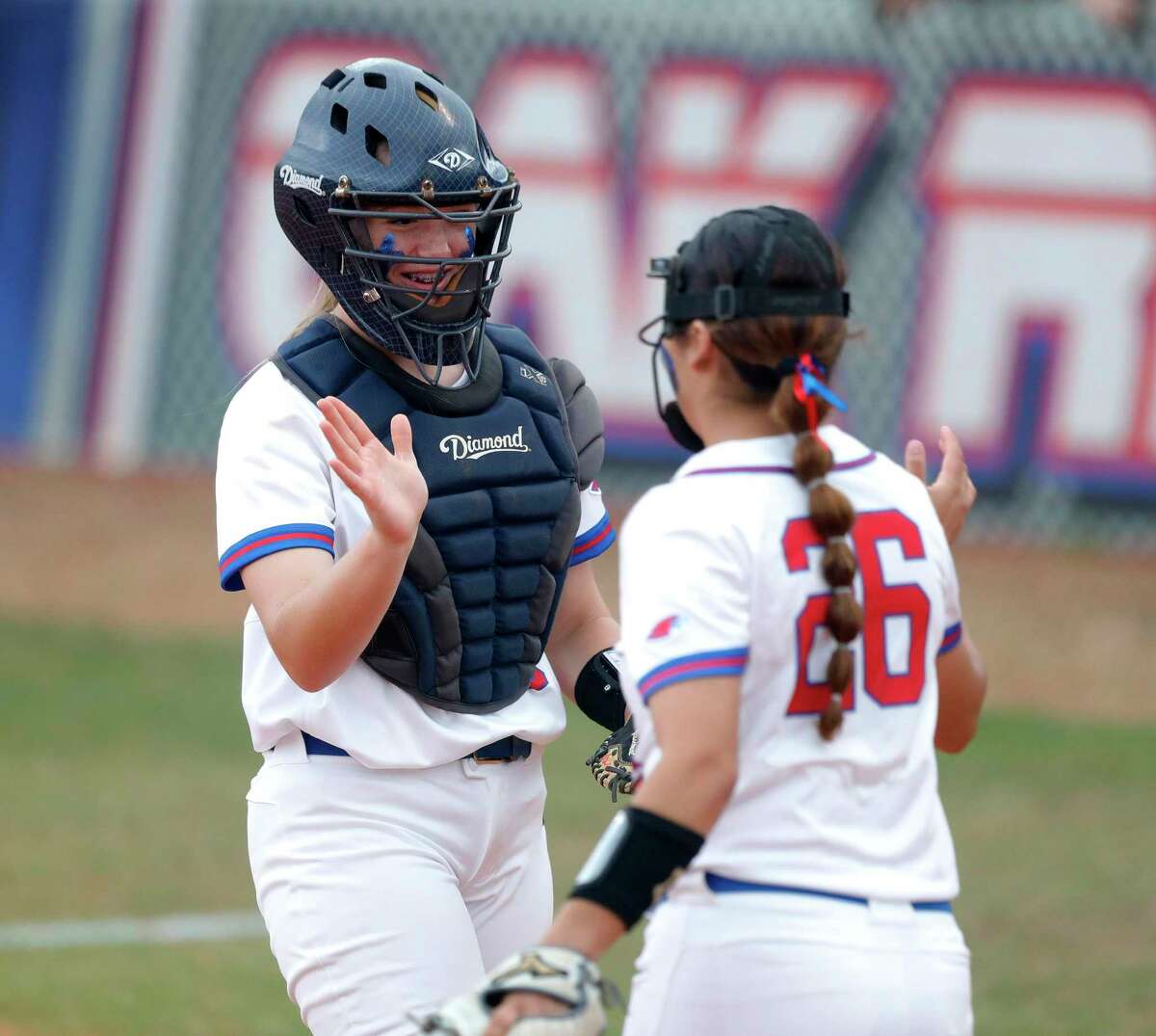 Oak Ridge catcher Ella Boyer (75) gets a high-five from first baseman Alexia Villegas (26) after catching a fly ball by Jasmine Bouziri #2 of College Park in the first inning of a District 13-6A high school softball game at Oak Ridge High School, Tuesday, April 19, 2022.