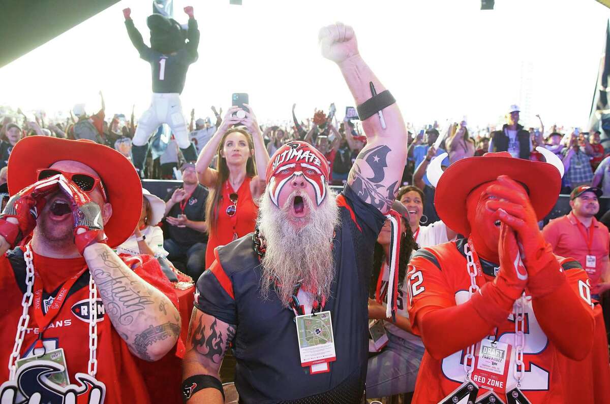Texans fans Jonathon Montes aka Red Amigos, Steve Beckholt aka Ultimate fan and Mike Blansett aka Red Bull react to the Texan’s first round draft pick at a Texans draft party at Miller Amphitheater in Houston on Thursday, April 28, 2022.