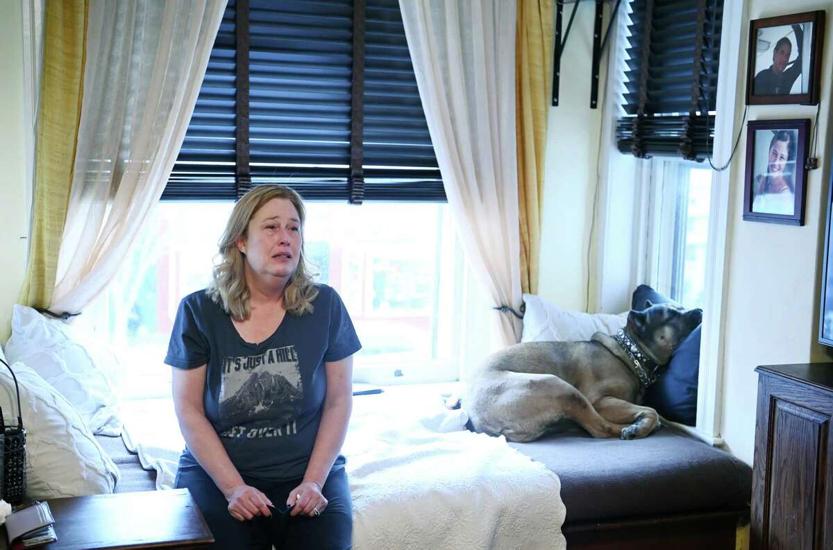 Arianne Bennett in her Northwest D.C. apartment. Her husband, Scott Bennett, in the photo at top right, died of covid-19 in January. He was fully vaccinated and boosted.