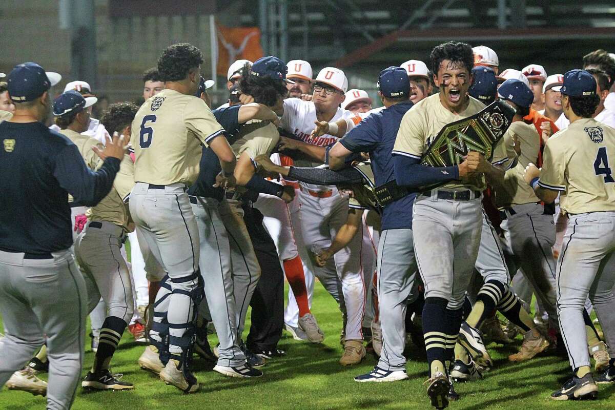 Alexander’s Emir Encalada celebrates the Bulldogs’ District 30-6A championship as a fight breaks out in the background.