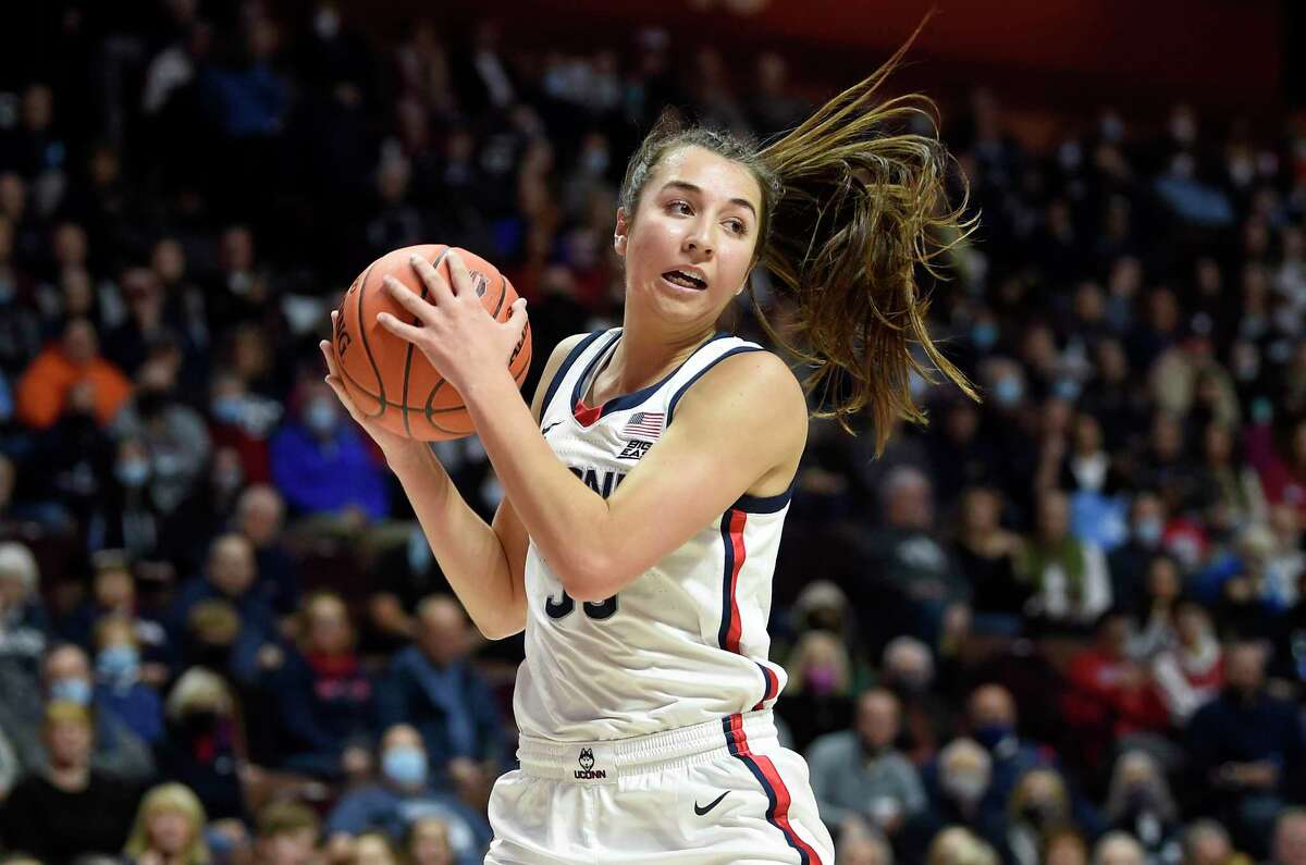 UNCASVILLE, CONNECTICUT - DECEMBER 19: Caroline Ducharme #33 of the Connecticut Huskies grabs a rebound against the Louisville Cardinals in the Basketball Hall of Fame Women's Showcase at Mohegan Sun Arena on December 19, 2021 in Uncasville, Connecticut. (Photo by G Fiume/Getty Images)