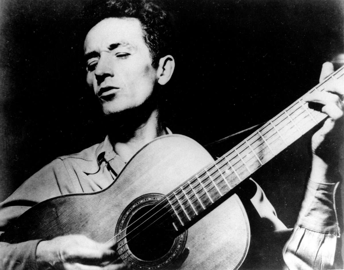 In this undated photo Oklahoma folk singer Woody Guthrie plays his guitar. His song “This Land is Your Land,” speaks to the nation’s moral soul with beauty and honesty. It should be our national anthem.