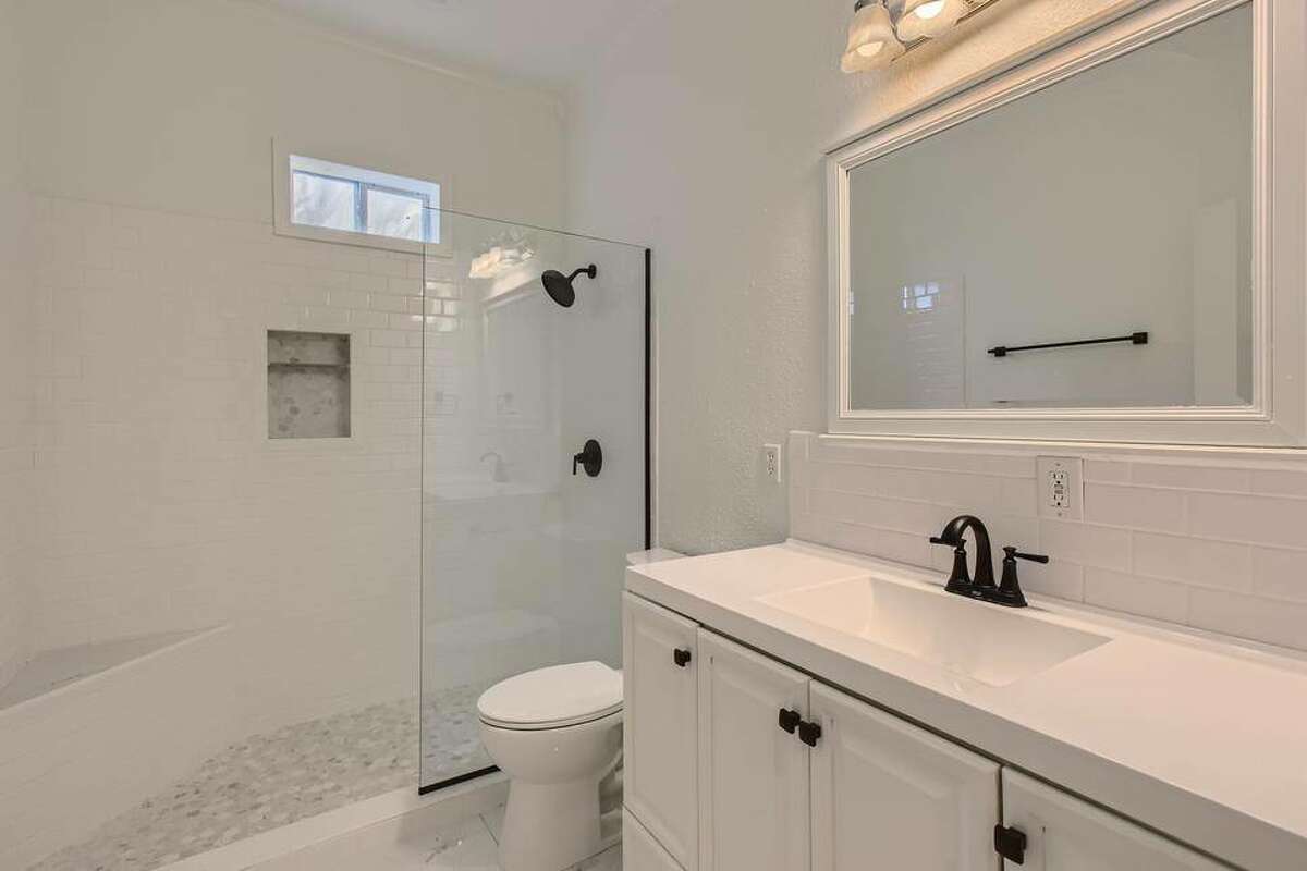 This updated bathroom and walk-in shower use black steel fixtures.