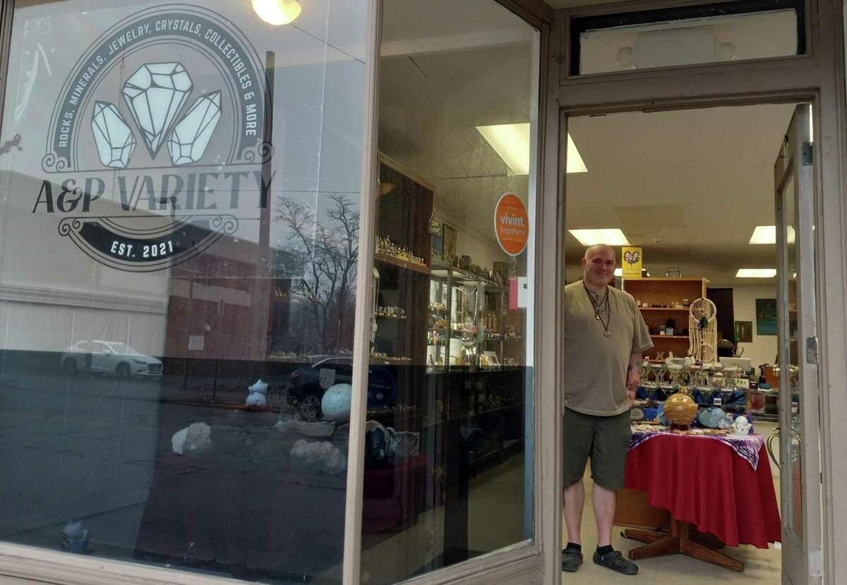 Mike Derosier stands in the doorway of his shop, A&P Variety, a crystal and gift store on Water Street.