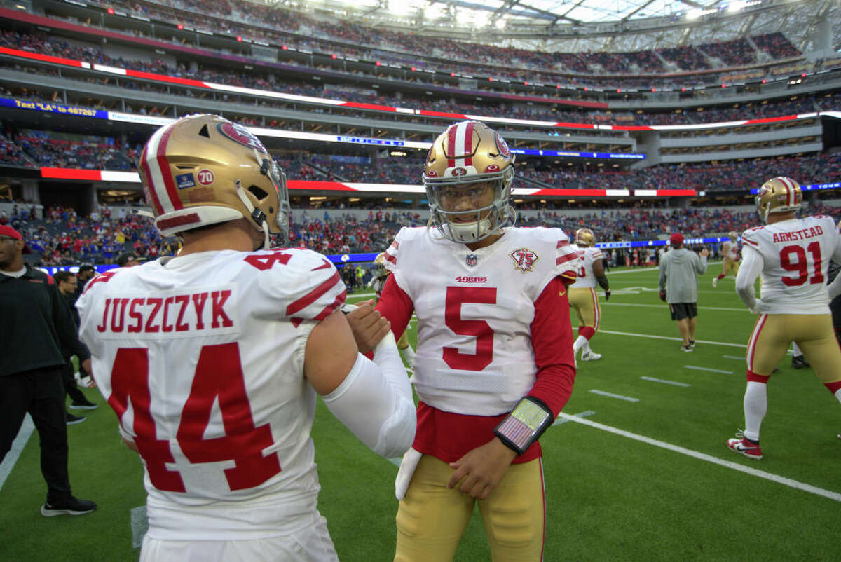 Kyle Juszczyk and Trey Lance of the San Francisco 49ers meet on the field before the game against the Los Angeles Rams at SoFi Stadium on January 30, 2022 in Inglewood, California. 