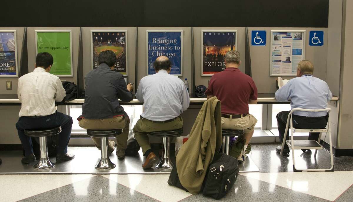 Business travelers read their computer email at a United Airlines O'Hare International Airport gate.