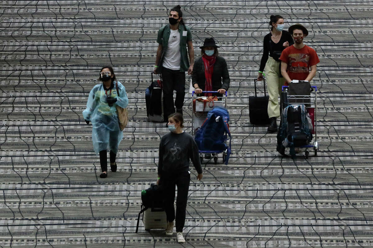 Travellers wearing protective mask walk along the transit area of Changi International Airport terminal in December 2020 in Singapore.