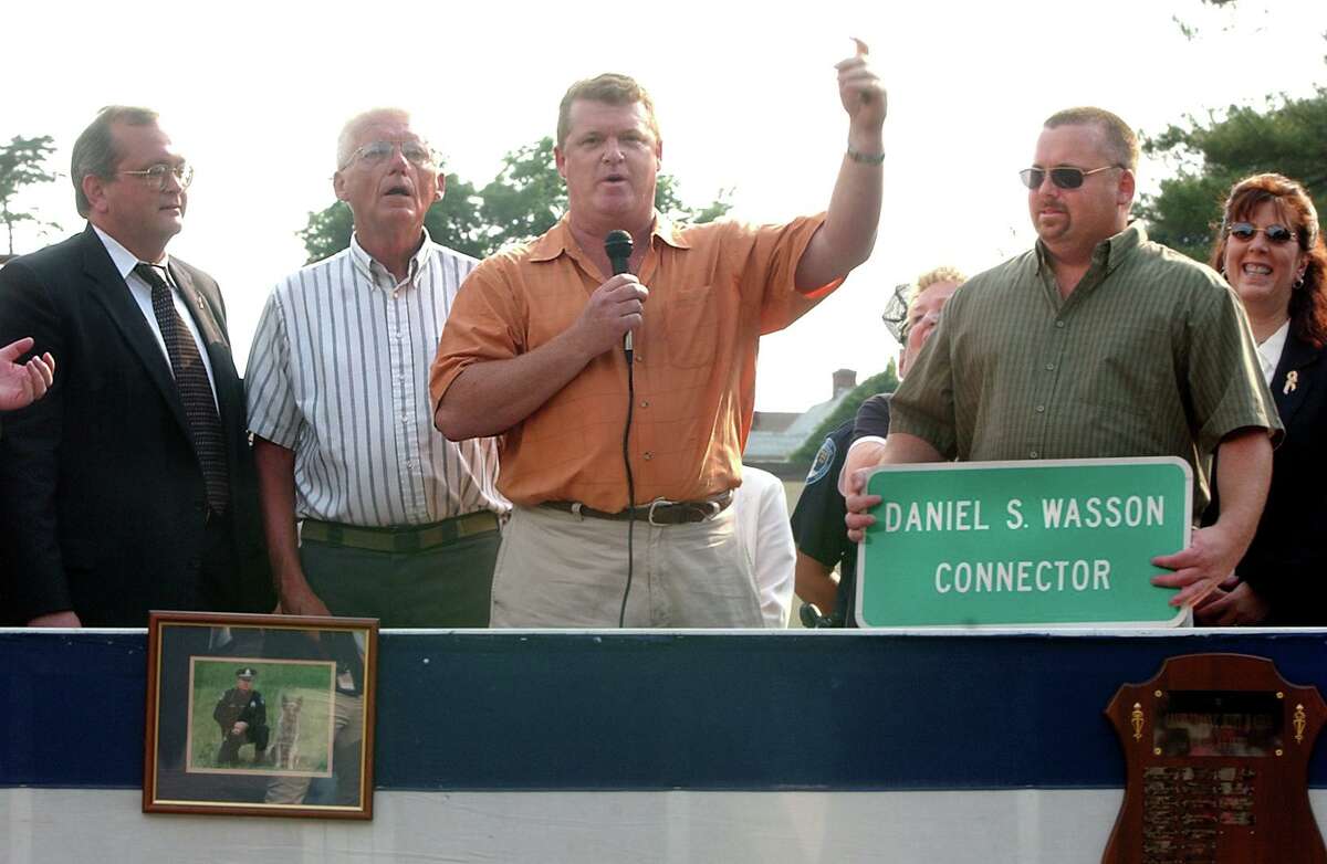 In 2003, Ray Wasson, brother of slain Milford Officer Daniel Wasson, speaks on behalf of the Wasson family at a ceremony dedicating the Park and Ride Commuter lot on Route 1 in Milford. from left Sen Winn Smith, Ed Wasson (father), Ray and Jeff Wasson. (brothers).