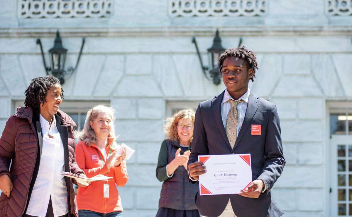 Caleb Boateng, a Brunswick School student, receives a scholarship and certificate during the Stand Against Racism demonstration Friday, April 29, 2022.