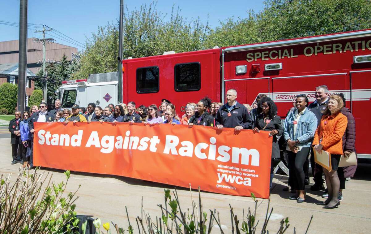 Participants at the YWCA Greenwich’s Stand Against Racism event pose with the banner for a photo before hanging it on the fire truck. The truck will remain in front of Greenwich Town Hall to remind the community of a commitment to anti-racism.