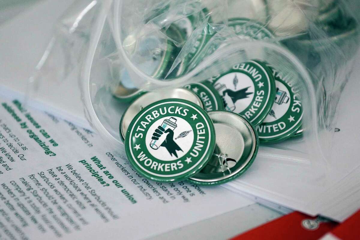 Pro-union pins sit on a table during a watch party for Starbucks' employees union election, Dec. 9, 2021, in Buffalo, N.Y. The top lawyer for the National Labor Relations Board said Thursday, April 7, she will ask the board to rule that mandatory meetings some companies hold to persuade their workers reject unions is in violation of federal labor law. (AP Photo/Joshua Bessex, File)
