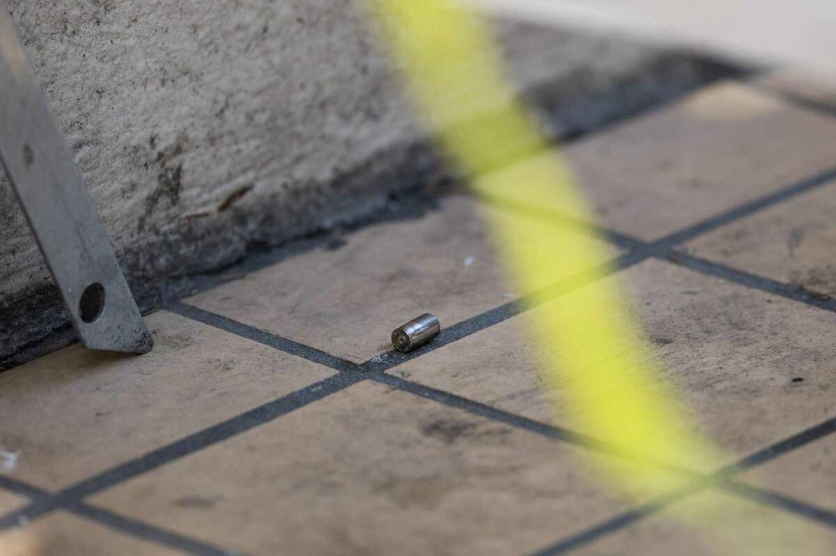 A bullet casing lies on the ground behind a police line where a man was shot outside 350 Turk St. in the Tenderloin.