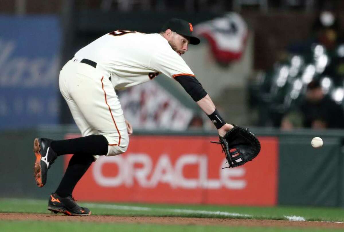 San Francisco Giants’ Brandon Belt fields a grounder by San Diego Padres’ Jake Cronenworth in 5th inning during MLB game at Oracle Park in San Francisco, Calif, on Monday, April 11, 2022.