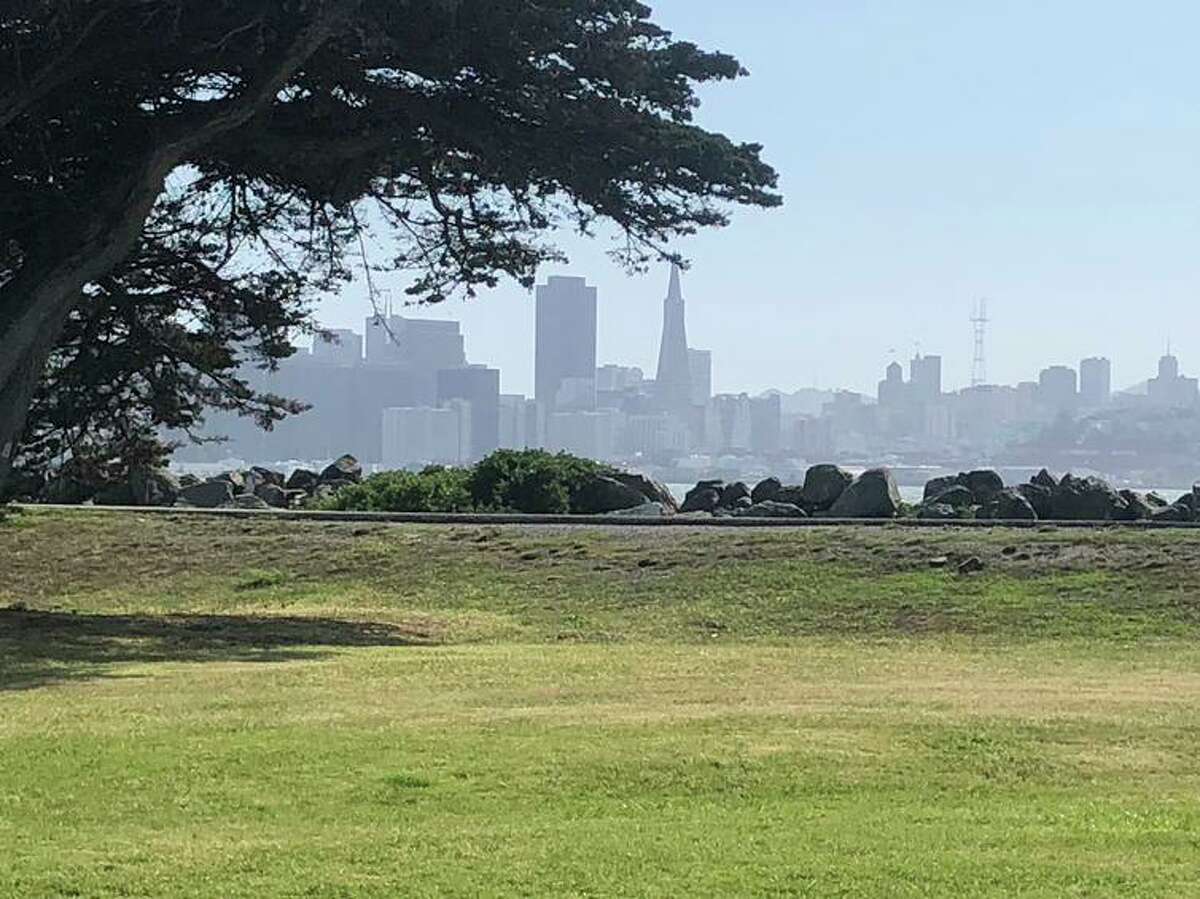 The skyline of San Francisco, all hills and towers, rises across the bay from Treasure Island.