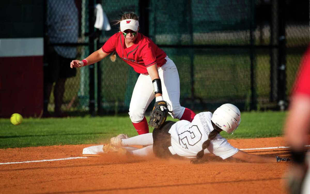 Spring Belle De Los Santos slides in under the glove of The Woodlands Emma Landauer to reach third base in a Region II-6A bi-district softball playoff game Friday, Apr 29, 2022, in The Woodlands.