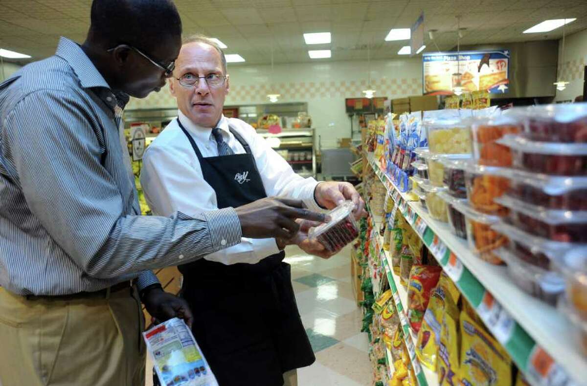Gary Cuomo, produce manager at the Ansonia Big Y store, questions Valentine Njike about the NuVal food scoring system Friday Oct. 1, 2010 at the supermarket in Ansonia. Big Y stores across the state are rolling out the system which awards foods a numeric score between 1 and 100 based on their nutritional value. Njike is the assistant director of research and evaluation for the Yale-Griffin Prevention Research Center, the group responsible for NuVal.