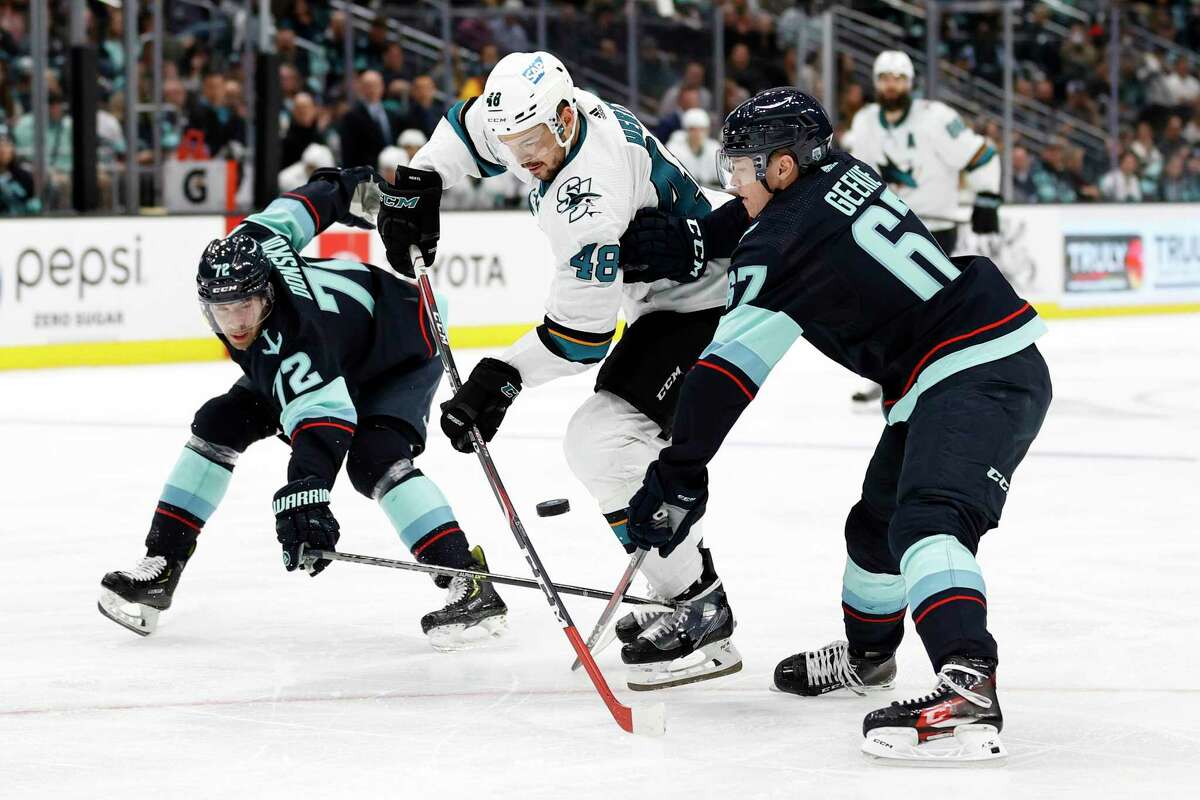 The Sharks’ Tomas Hertl controls the puck against the Kraken’s Joonas Donskoi (72) and Morgan Geekie (67) during the third period at Climate Pledge Arena in Seattle on Friday night.