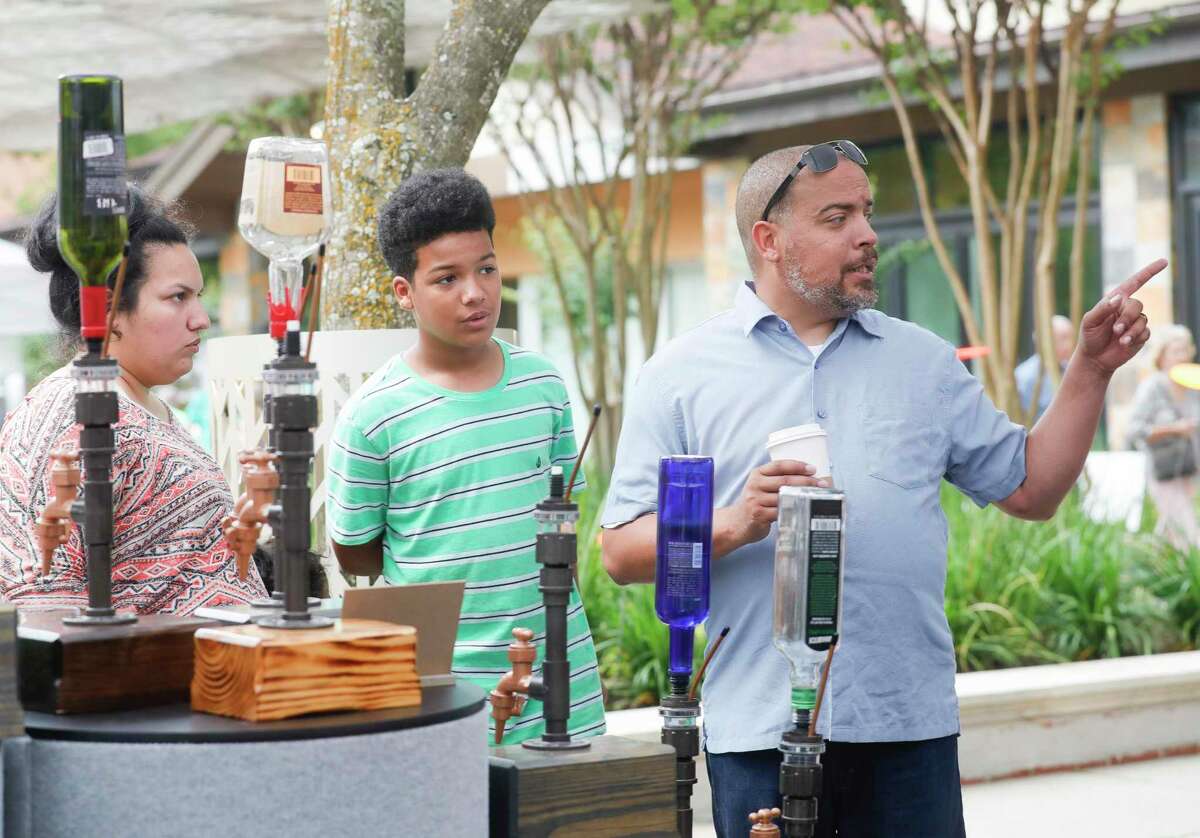 Jason Turner looks artistic beverage dispensers during the annual Spring Fine Arts Show at Market Street, Saturday, April 30, 2022, in Conroe. Families browsed various art booths, enjoyed live music, and participate in artist demonstrations.