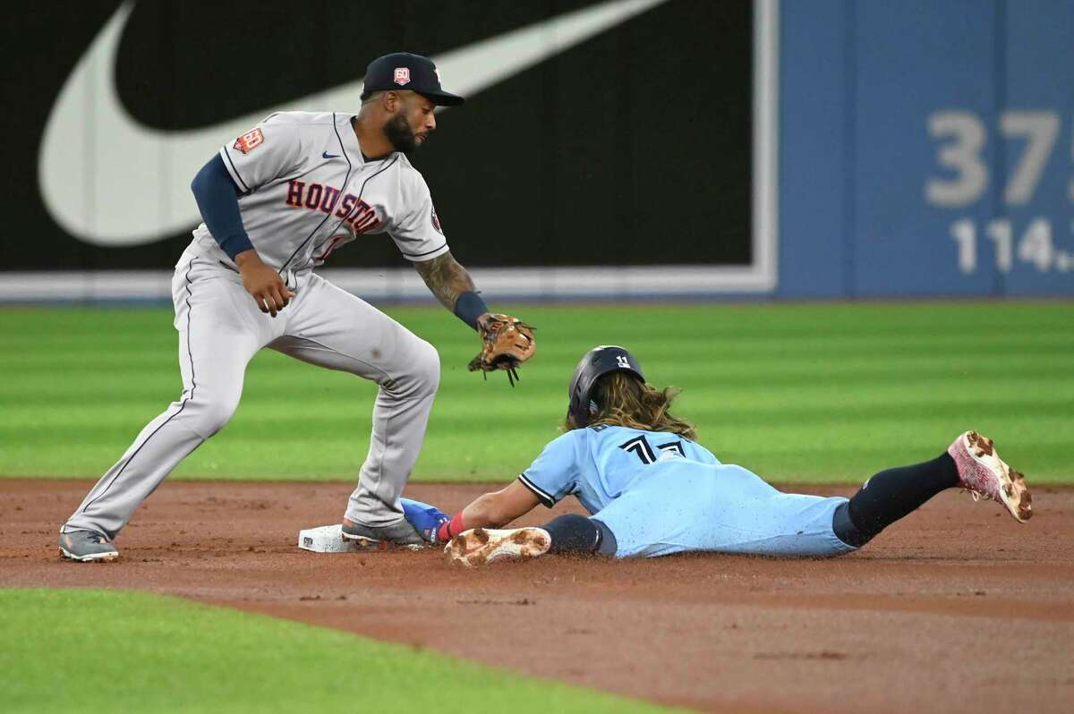 Toronto Blue Jays' Bo Bichette, right, steals second base ahead of the tag by Houston Astros' Niko Goodrum in the first inning of a baseball game in Toronto, Saturday, April 30, 2022. (Jon Blacker/The Canadian Press via AP)