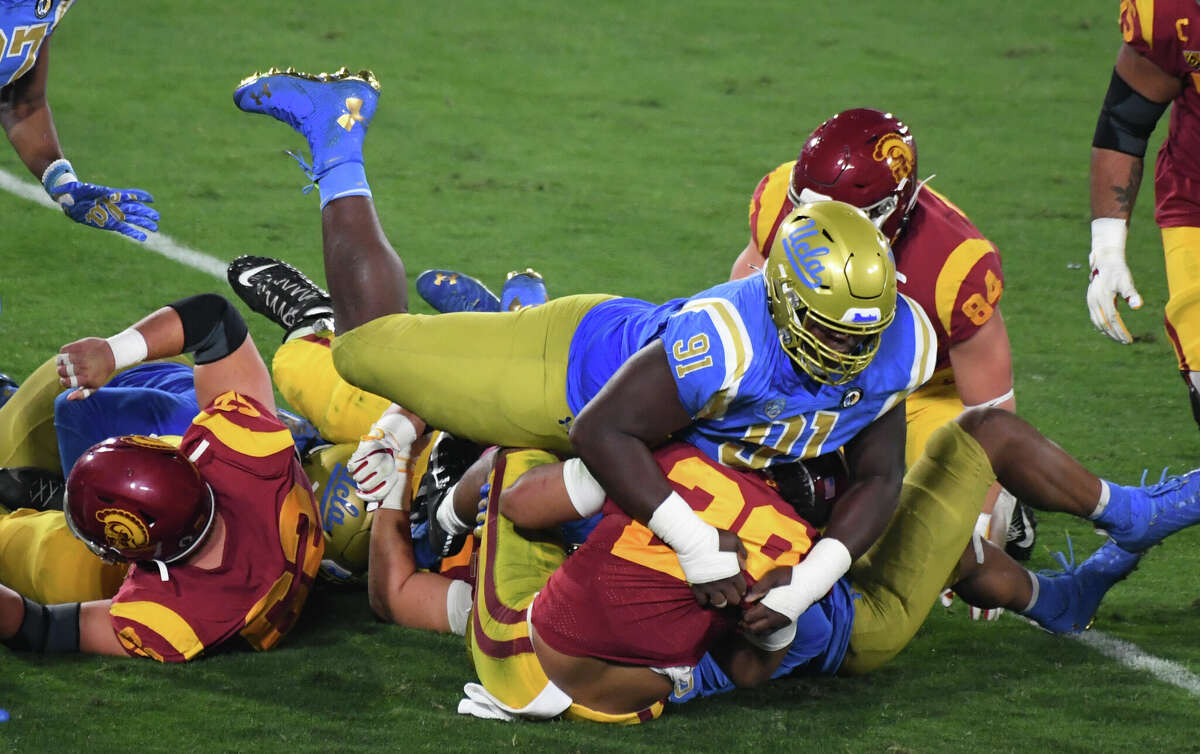 Pasadena, CA - December 12: Defensive lineman Otito Ogbonnia #91 of the UCLA Bruins tackles running back Vavae Malepeai #29 of the USC Trojans in the second half of a NCAA Football game at the Rose Bowl in Pasadena on Saturday, December 12, 2020. (Photo by Keith Birmingham/MediaNews Group/Pasadena Star-News via Getty Images)