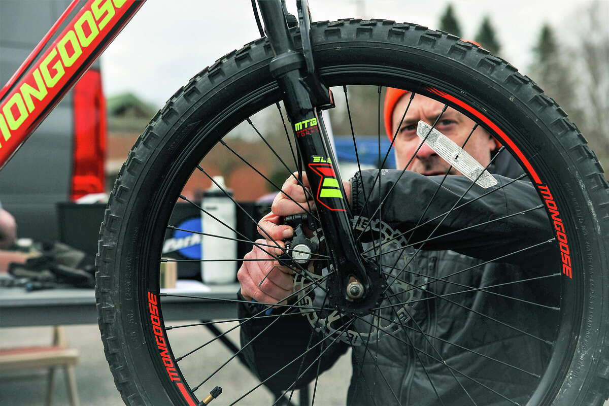 Derek Roesler checks a tire on a bicycle at the bike rodeo event at West Shore Community College in Scottville on Saturday. Roesler is the manager at Spindrift Cyclesports, a bike shop that partnered with the college and other community organizations for the event.