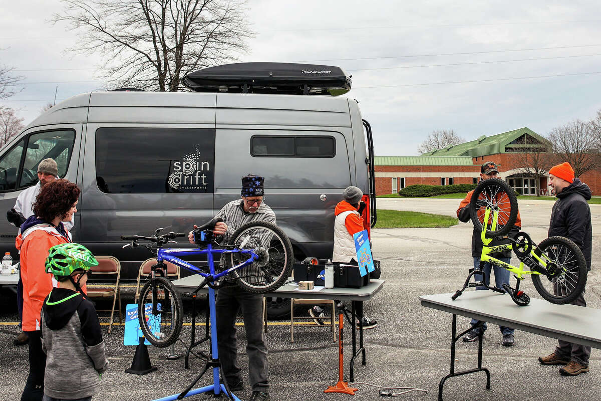 Dave Maclean(center) checks the tires of a bicycle during the "bike" rodeo at West Shore Community College in Scottville on Saturday. The event was organized to promote bicycle safety for kids. 