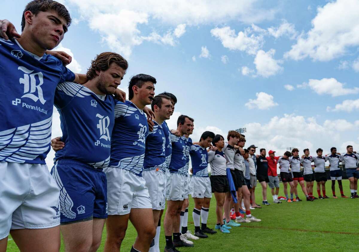 Members of the Rice University rugby team bow their heads before a memorial rugby tournament held to honor the memory of Pedrie Wannenburg, a South African rugby player and coach who had a profound influence on the game in Houston including coaching at Rice University, on the practice fields at Aveva Stadium on Saturday afternoon, April 30, 2022, in Houston. Wannenburg was killed in a car crash earlier in April.