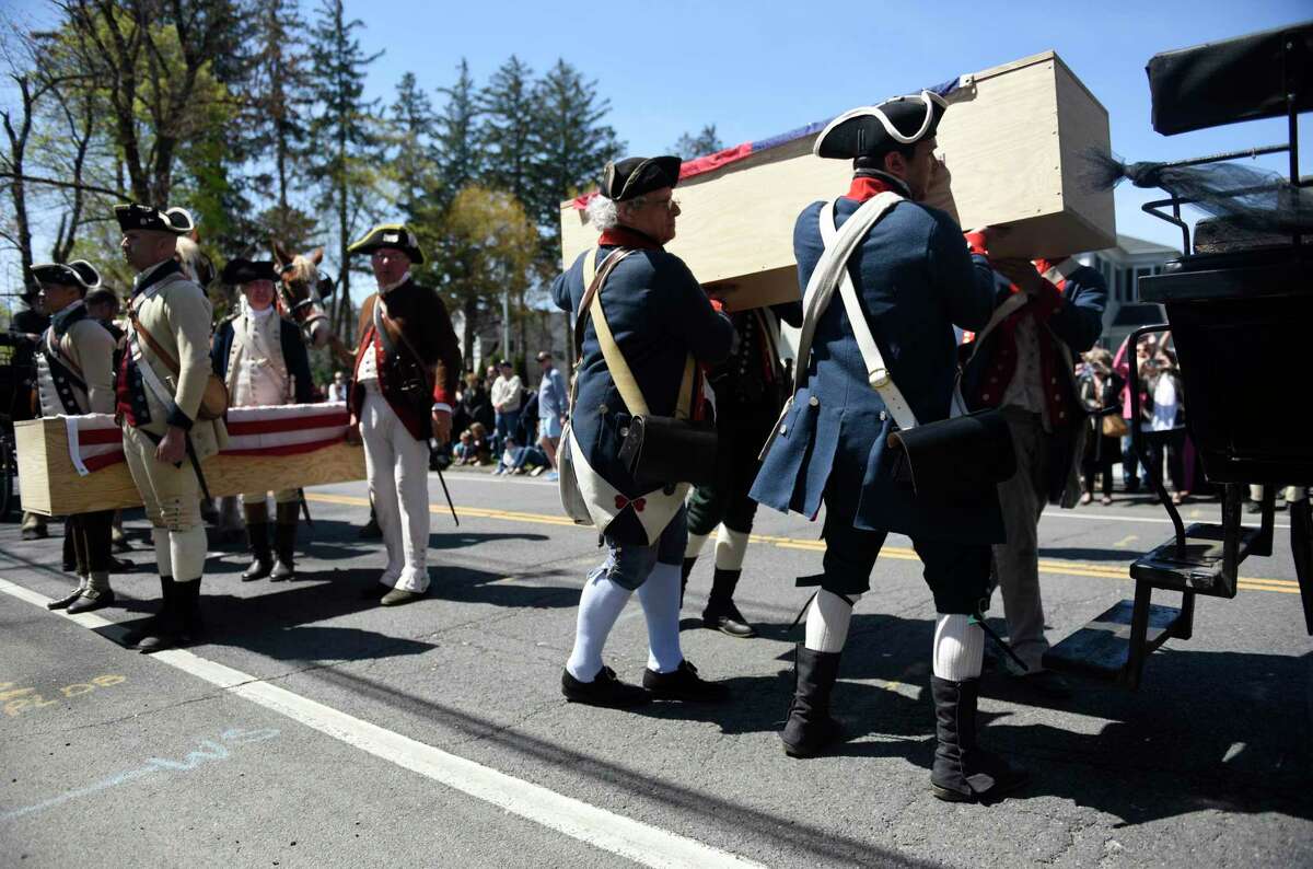 Revolutionary War reenacters carry caskets of fallen soldiers during the Battle of Ridgefield Funeral Procession and Ceremonial Salute in Ridgefield, Conn. Sunday, May 1, 2022. The 245th anniversary of the Battle of Ridgefield was remembered with a funeral procession and ceremony, led by the 5th Connecticut Regiment and the Brigade of the American Revolution. The men who died in battle in 1777 received a formal recognition for the first time at the ceremony, which featured hundreds of Revolutionary War reenacters. Troops marched through town with two horse-drawn carriages to the cemetery, where soldiers placed four caskets in a special tribute honoring their lives.