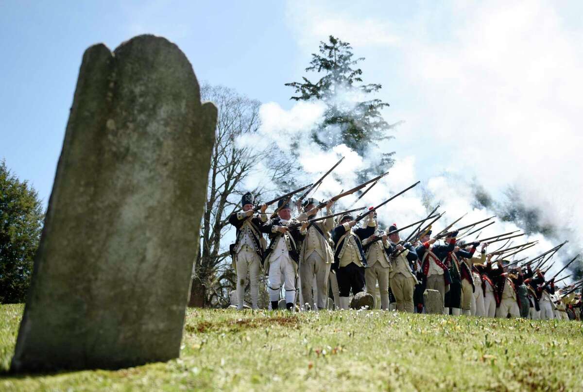 Revolutionary War reenacters shoot their guns for a musket salute during the Battle of Ridgefield Funeral Procession and Ceremonial Salute at Olde Town Cemetery in Ridgefield, Conn. Sunday, May 1, 2022. The 245th anniversary of the Battle of Ridgefield was remembered with a funeral procession and ceremony, led by the 5th Connecticut Regiment and the Brigade of the American Revolution. The men who died in battle in 1777 received a formal recognition for the first time at the ceremony, which featured hundreds of Revolutionary War reenacters. Troops marched through town with two horse-drawn carriages to the cemetery, where soldiers placed four caskets in a special tribute honoring their lives.