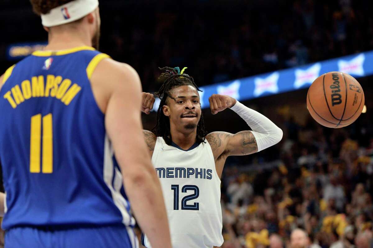 Memphis Grizzlies guard Ja Morant (12) reacts after scoring as Golden State Warriors guard Klay Thompson (11) looks on during Game 1 of a second-round NBA basketball playoff series Sunday, May 1, 2022, in Memphis, Tenn. (AP Photo/Brandon Dill)