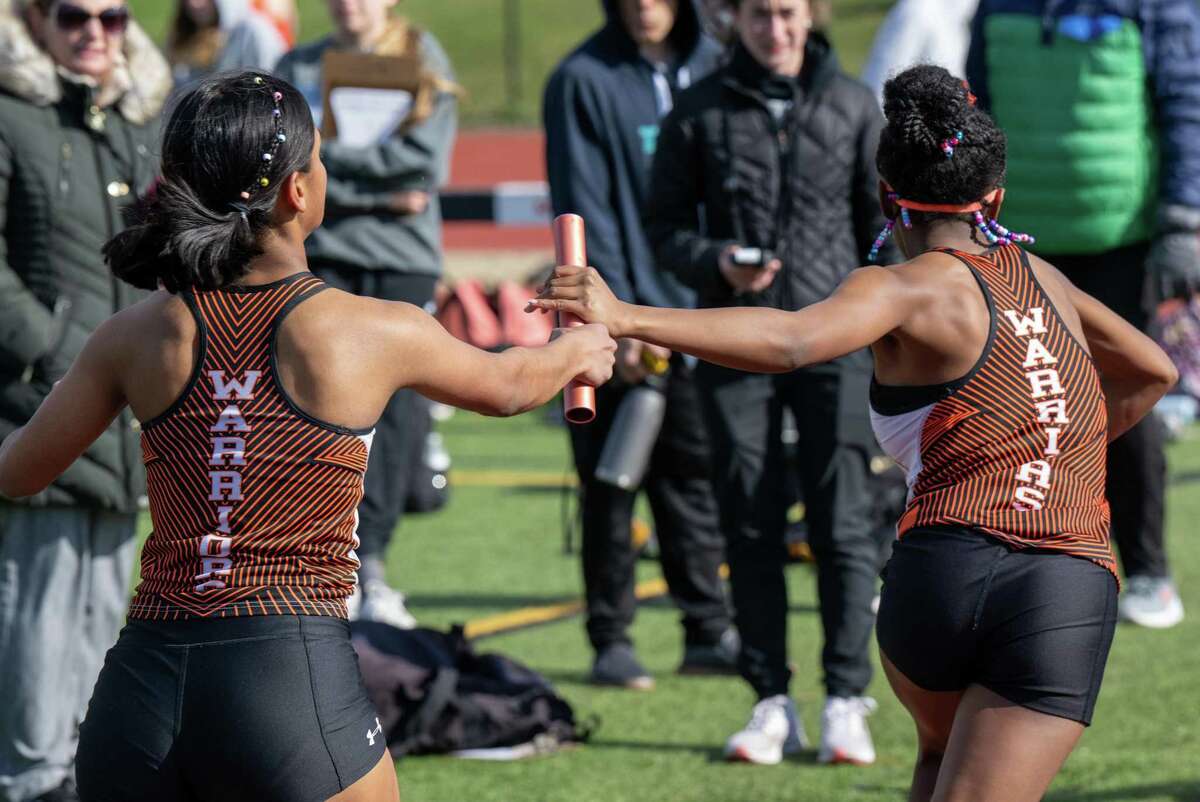 With beads in their hair, Mohonasen track runner Bonnieta Supaul hands the baton to Zoe Miller during a Colonial Council track meet at Mohonasen High School in Rotterdam on Wednesday, April 27, 2022. (Jim Franco/Special to the Times Union)