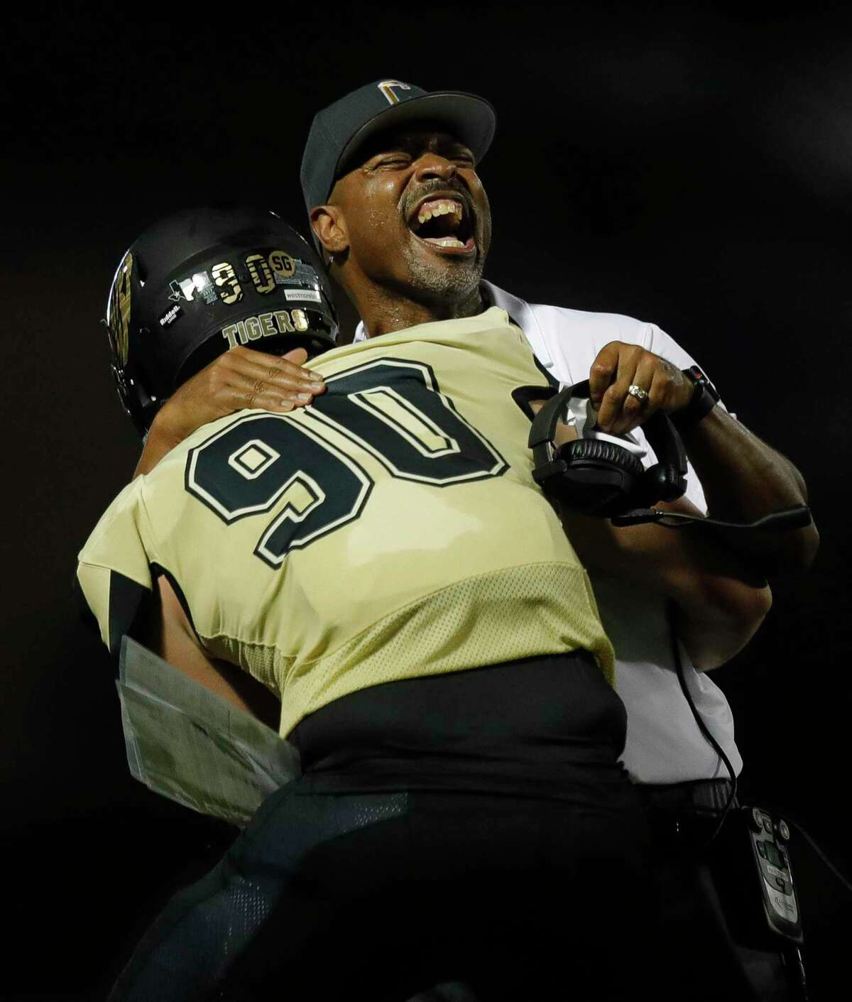 Conroe head coach Cedric Hardeman embraces defensive lineman Matthew Westmoreland (90) after he returned an interception for a 45-yard touchdown during the third quarter of a non-district high school football game at Buddy Moorhead Stadium, Friday, Aug. 27, 2021, in Conroe.