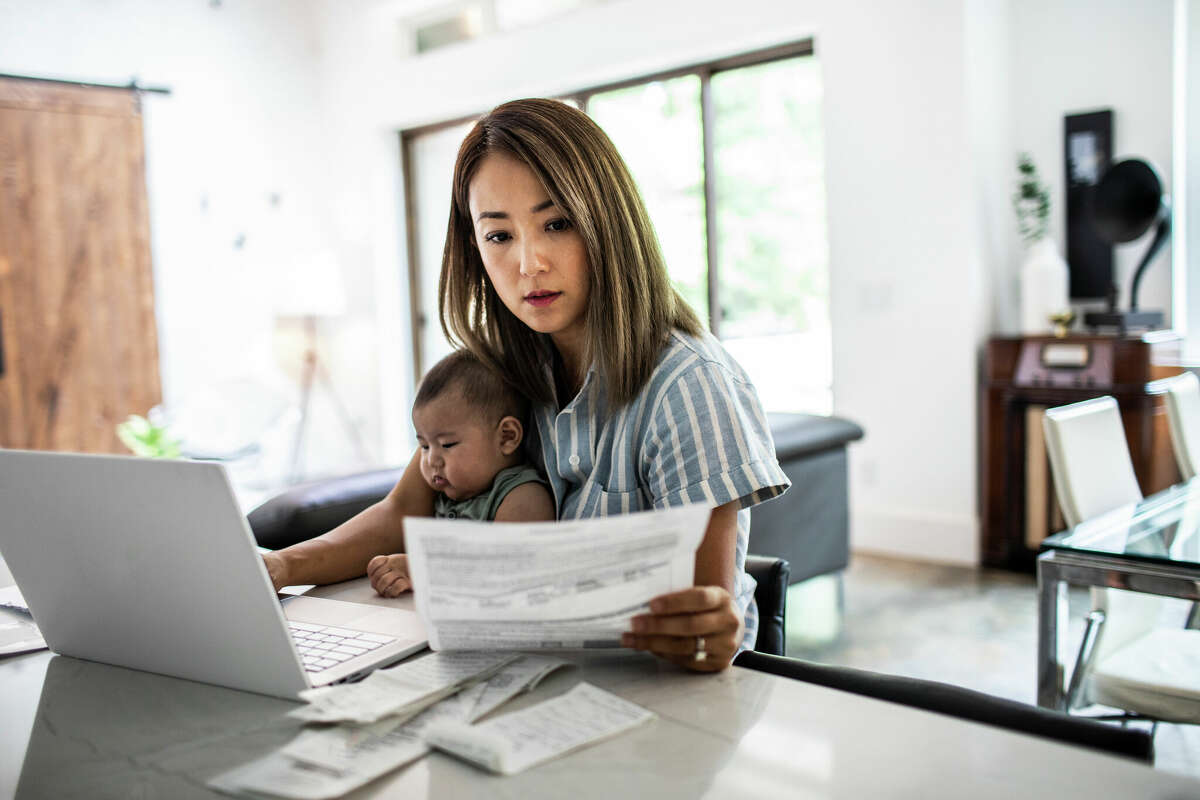 Mother working from home while holding baby. 