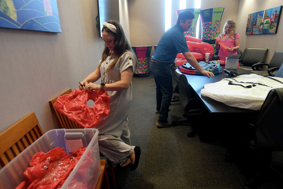 From left, Sophia Bouey, John Beaver and Sarah Wells help blow up balloons during a "working lunch" volunteer event at the Beaumont Convention and Visitor's Bureau to prepare for May's Artaco event. Photo made Thursday April 28, 2022. Kim Brent/The Enterprise